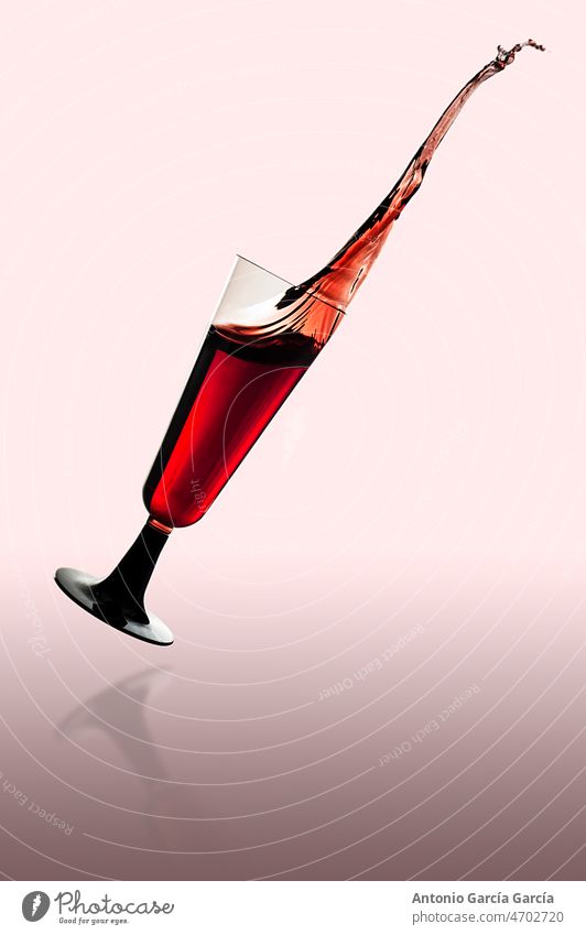 Weinglas, das auf eine spiegelnde Oberfläche fällt Brille Alkohol rot trinken Glas vereinzelt strömender Regen liquide Flaschen Getränk weiß Feier eingießen Bar