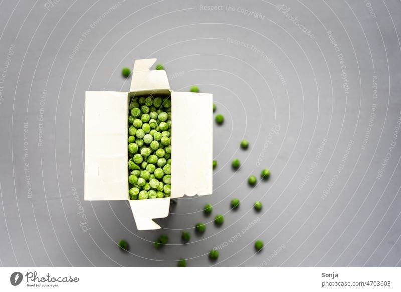 Gefrorene Erbsen in einem Karton auf einem grauen Hintergrund gefroren Draufsicht Tisch Lebensmittel Gesundheit Gemüse Vegetarier organisch grün