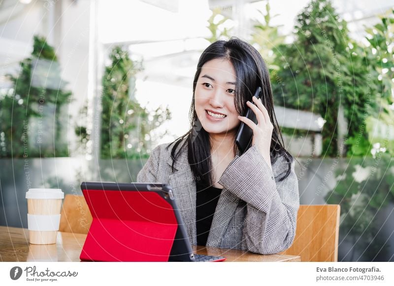 professionelle chinesische Unternehmerin, die in der Cafeteria am Handy arbeitet. Technologie, Lebensstil Chinesisch asiatisch Frau Laptop Technik & Technologie