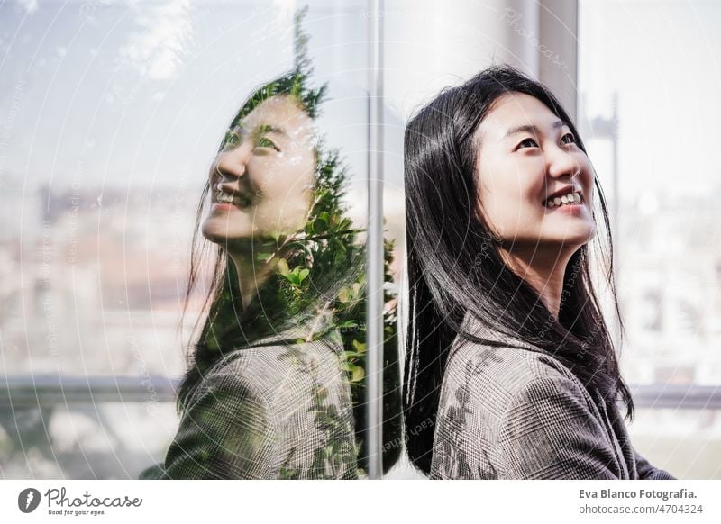 Porträt einer erfolgreichen chinesischen Geschäftsfrau, die im Büro lächelt. Reflexion auf Glas Chinesisch asiatisch Frau Laptop Technik & Technologie Café