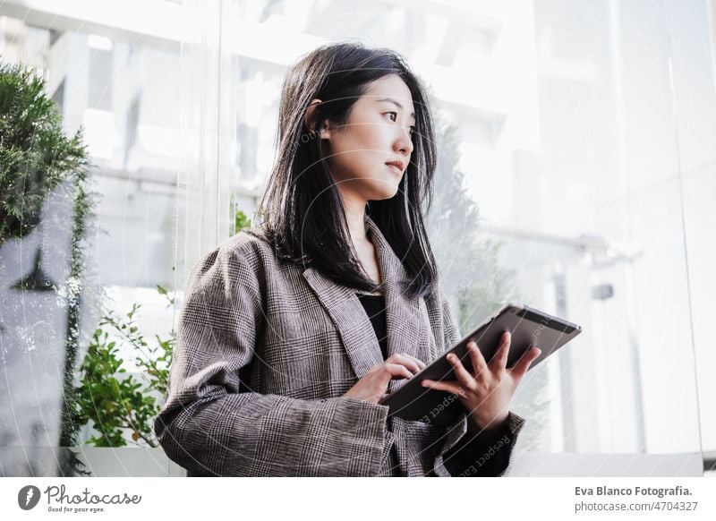 Porträt einer schönen chinesischen Geschäftsfrau, die ein digitales Tablet in einem Büro benutzt. Technologie Chinesisch asiatisch Frau Laptop