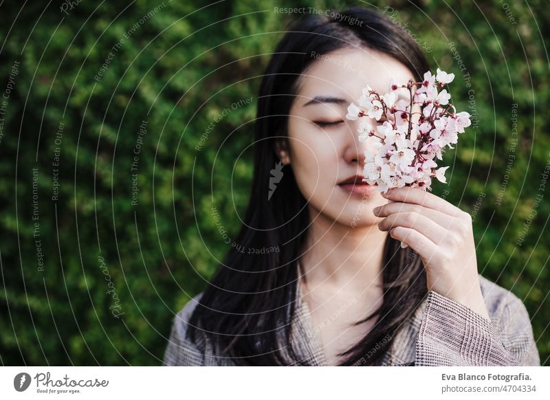 schöne chinesische asiatische Frau hält Mandelbaum Blumen.Frühling. selektiven Fokus auf Blumen Chinesisch Porträt Natur Großstadt Orientalisch jung grün