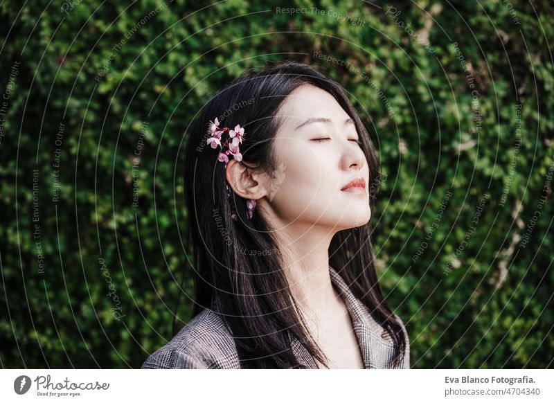 Porträt der schönen chinesischen asiatischen Frau mit geschlossenen Augen und Mandelbaum flowers.Spring Zeit, entspannen Chinesisch Frühling Blumen Natur