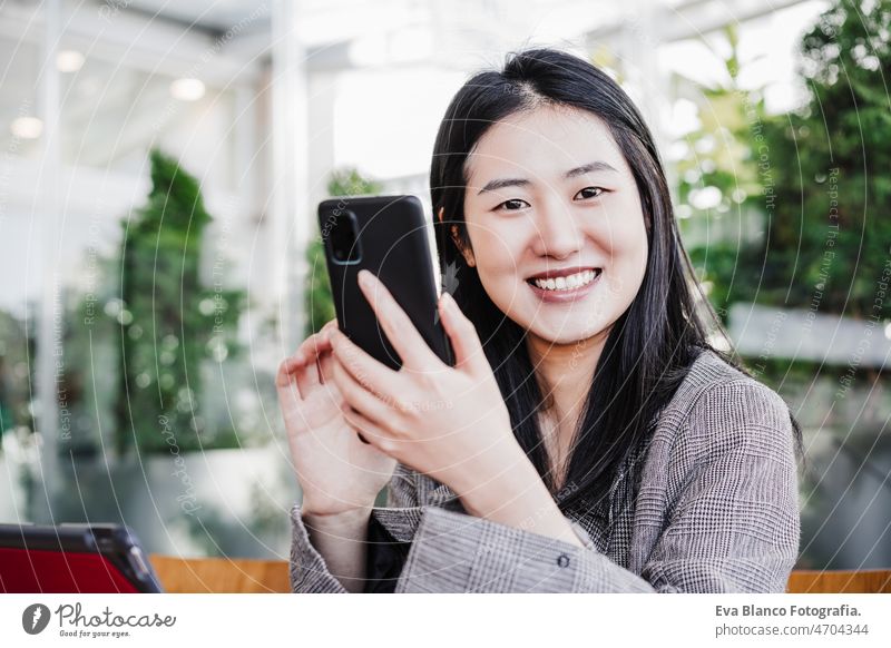 glückliche geschäftsfrau im büro mit handy und digitalem tablet. büro und zusammenarbeit Chinesisch asiatisch Frau Laptop Technik & Technologie Café Kaffee
