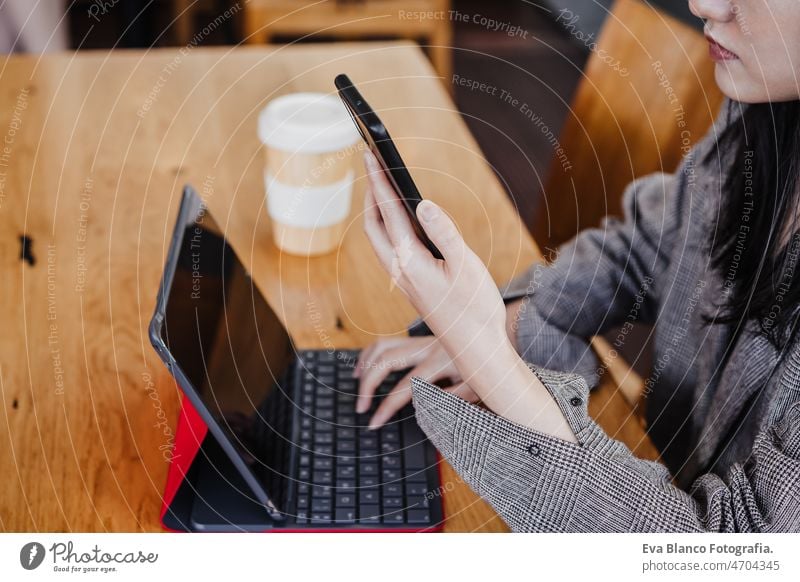 unerkennbare Geschäftsfrau, die mit digitalem Tablet und Handy im Büro arbeitet. Technologie unkenntlich Chinesisch asiatisch Frau Laptop Technik & Technologie