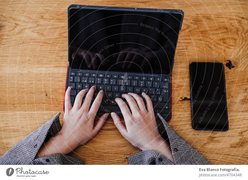 Draufsicht auf eine Geschäftsfrau, die mit einem digitalen Tablet und einem Mobiltelefon im Büro arbeitet. unkenntlich Chinesisch asiatisch Frau Laptop