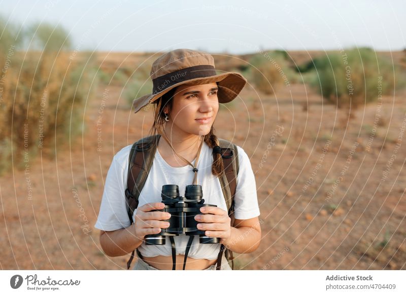 Frau mit Fernglas in einem Wüstenfeld Reisender Ausflug Abenteuer wüst trocken erkunden bewundern genießen Entfernung Inhalt froh Optimist Glück unfruchtbar