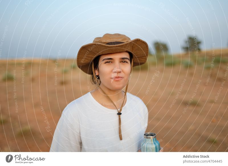 Frau trinkt Wasser in einem Wüstenfeld Reisender Ausflug Abenteuer wüst Durst Dürre trinken Hydrat Flasche erkunden unfruchtbar trocknen Buchse Vegetation