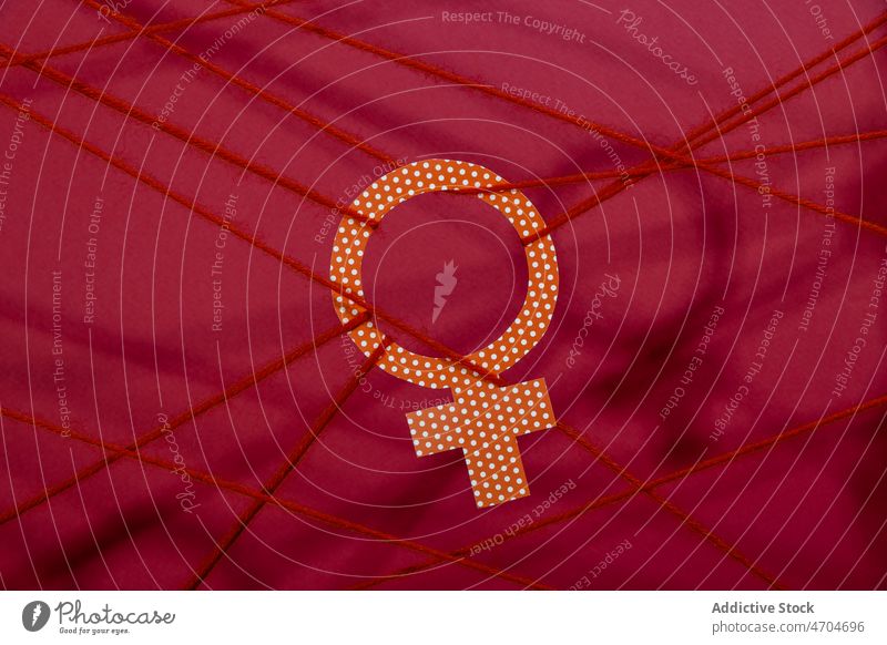 Venus-Symbol an Seilen hängend Frau Geschlecht Ungleichheit Konzept Vorurteil Diskriminierung Ungerechtigkeit Vielfalt gebunden orange Schatten halbdunkel