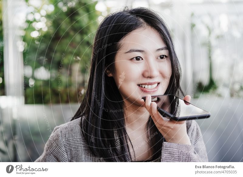 Porträt einer schönen chinesischen Geschäftsfrau, die ein Mobiltelefon in einem Büro benutzt. Technologie Chinesisch asiatisch Frau Laptop Technik & Technologie