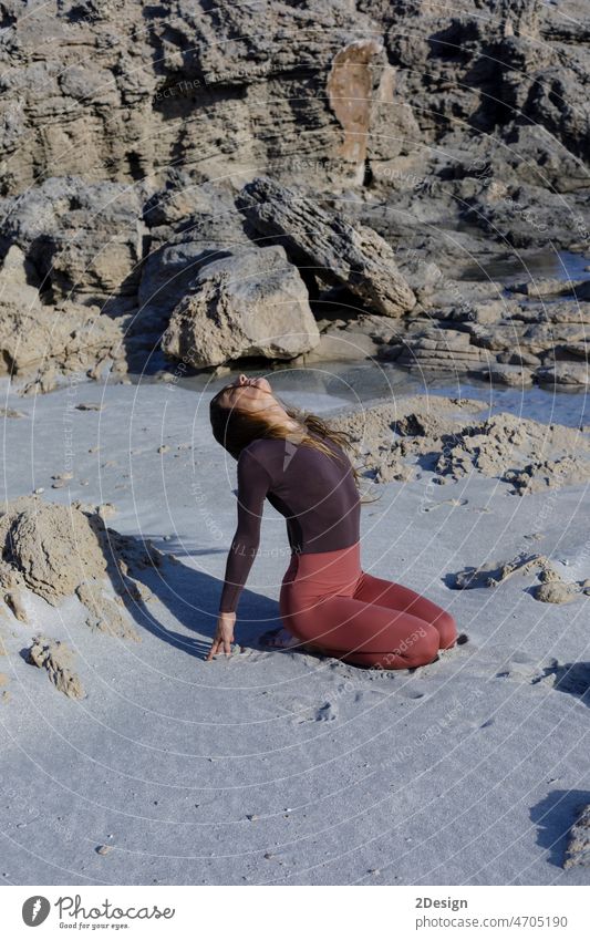 Junge Frau übt Balance-Asanas bei einer Sommer-Yoga-Sitzung an einem schönen Strand auf Formentera, Spanien Person Gleichgewicht Erholung MEER Übung Fitness