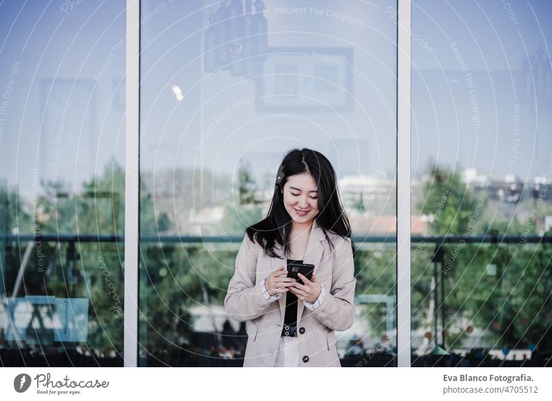 lächelnd schöne chinesische Geschäftsfrau mit Handy im Gebäude Büro. Technik Chinesisch asiatisch Frau Laptop Technik & Technologie Café Kaffee Kantine Tablette