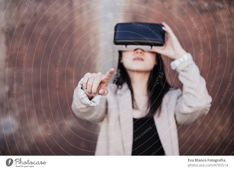 Chinesische Geschäftsfrau mit Virtual-Reality-Headset. Selektiver Fokus auf die Hände. Technologie Frau VR Schutzbrille Metaversum Realität virtuell attraktiv