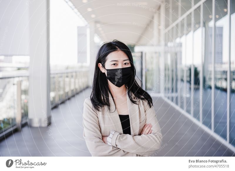 junge geschäftsfrau mit gesichtsmaske in der stadt. corona virus konzept Chinesisch Frau Gesichtsmaske Corona-Virus Pandemie Büro Zusammenarbeit Glas