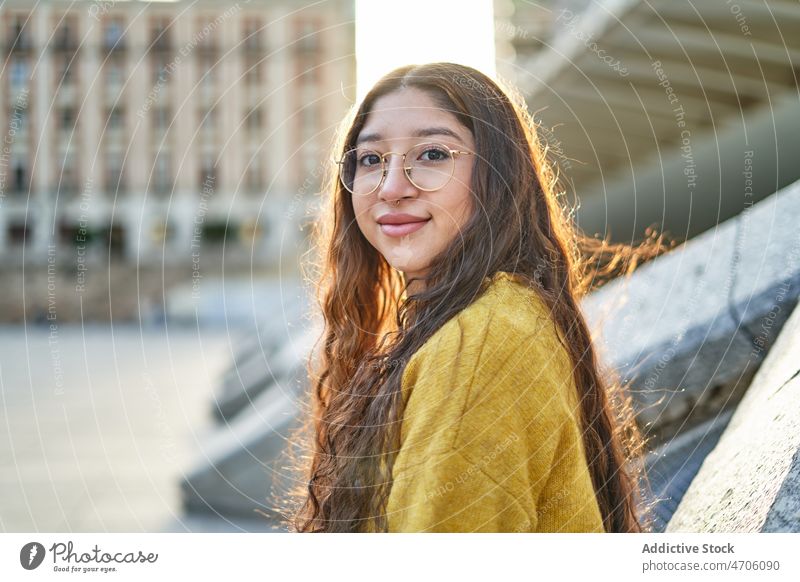 Fröhliche Frau steht in der Nähe einer Brücke Vorschein feminin Stil Straße Großstadt urban Lächeln Konstruktion jung genießen Sommer Brille angenehm