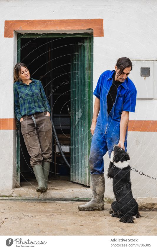 Arbeiterpaar streichelt Hund auf dem Lande Paar Landwirt Besitzer Kraulen Tier Haustier Landschaft ländlich Lebensraum rustikal Fauna Fussel bezaubernd Frau