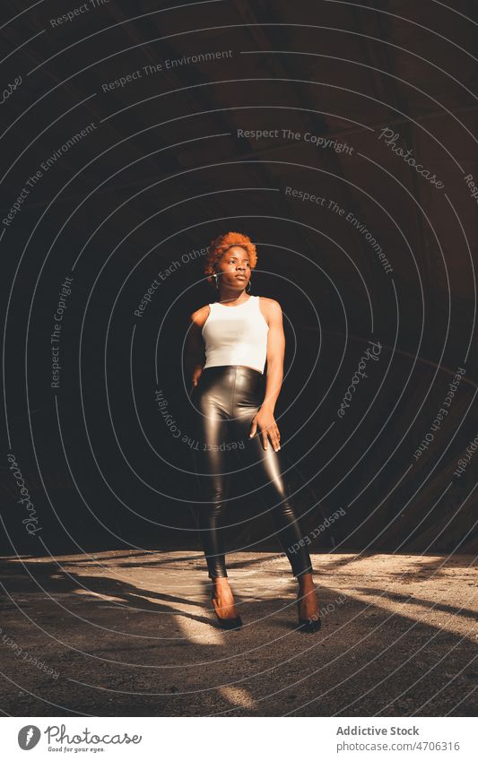 Stilvolle schwarze Frau im Tunnel trendy Stollen Sonnenlicht Mode Outfit feminin Bekleidung Vorschein Afroamerikaner selbstbewusst ernst Sonnenschein