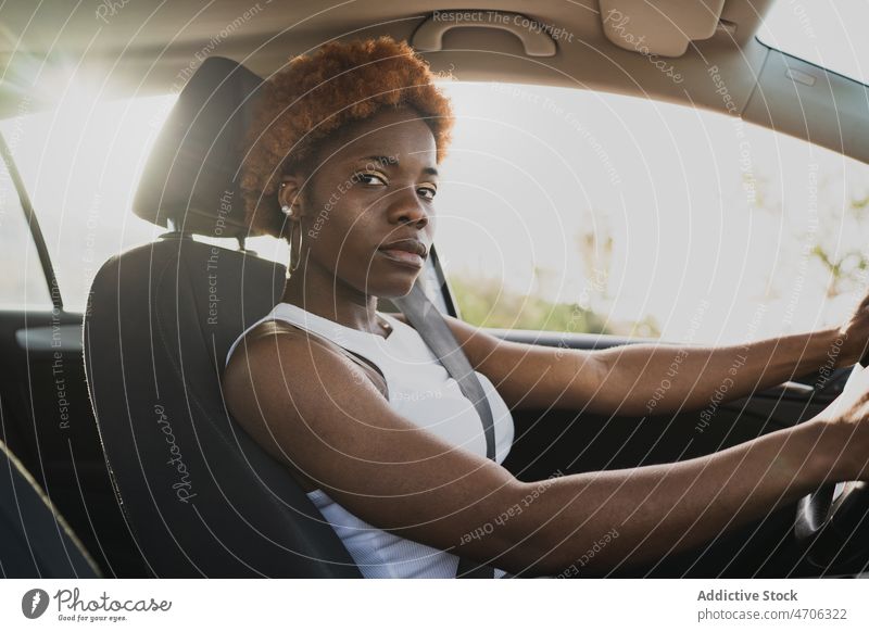 Afroamerikanische Frau fährt Auto an einem sonnigen Tag Fahrer PKW krause Haare Afro-Look Sommer reisen Frisur Sonne schwarz sitzen charmant Afroamerikaner