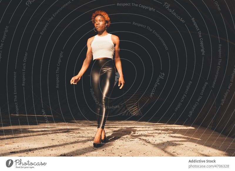 Stilvolle schwarze Frau im Tunnel trendy Stollen Sonnenlicht Mode Outfit feminin Bekleidung Vorschein Afroamerikaner selbstbewusst ernst Sonnenschein