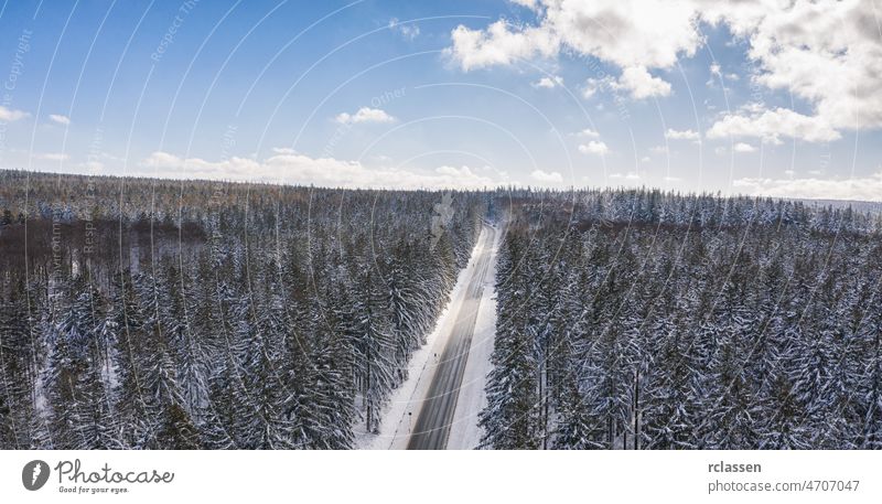 Luftaufnahme von Autos, die auf der Straße durch den verschneiten Winterwald und den bewölkten Himmel fahren, einschließlich Copy space Wald Dröhnen Antenne