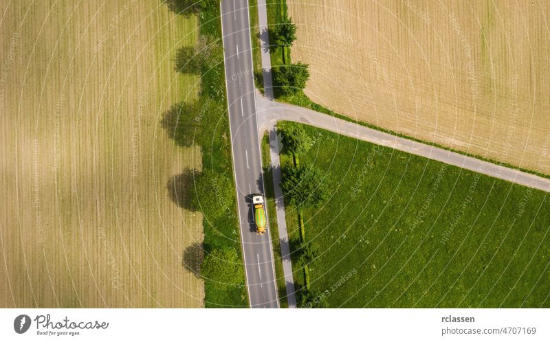 Luftaufnahme einer zweispurigen Straße durch ländliche Gebiete und bewirtschaftete Felder mit Autos. Drohnenaufnahme und Kopierraum für Text Dröhnen Fernstraße