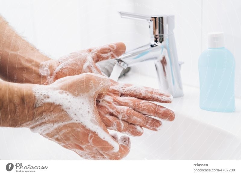 Händewaschen, Seife unter fließendem Wasser am Waschbecken abspülen, Coronavirus-Prävention, Händehygiene. Schutz vor Coronavirus-Pandemie durch häufiges Händewaschen.