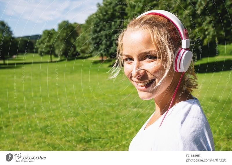 Läuferin beim Joggen im Park mit Kopfhörern. copyspace für Ihren individuellen Text. Glück Übung Frühling Sommer laufen Training joggen Textfreiraum Fitness