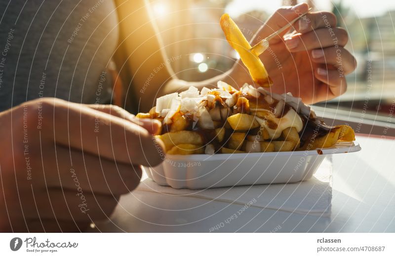 Deutsche Pommes frites mit Mayonnaise, Ketchup und frischen Zwiebeln in der Stadt Currywurst Lebensmittel Deutschland Markt Sonnenlicht Barbecue Kaukasier