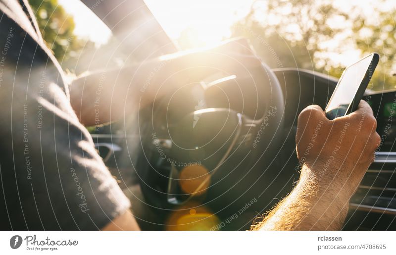 Mann schaut beim Autofahren auf sein Mobiltelefon Telefon Laufwerk PKW Fahrer Zelle App Funktelefon Mobile Unfall Blick benutzend Aufmerksamkeit gefährlich Halt