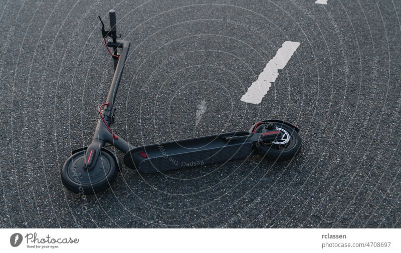 Elektroroller oder E-Scooter liegt nach einem Unfall auf der Straße, Konzeptbild Elektrischer Stadtverkehr Tretroller Großstadt Kick E-Roller Stadtzentrum
