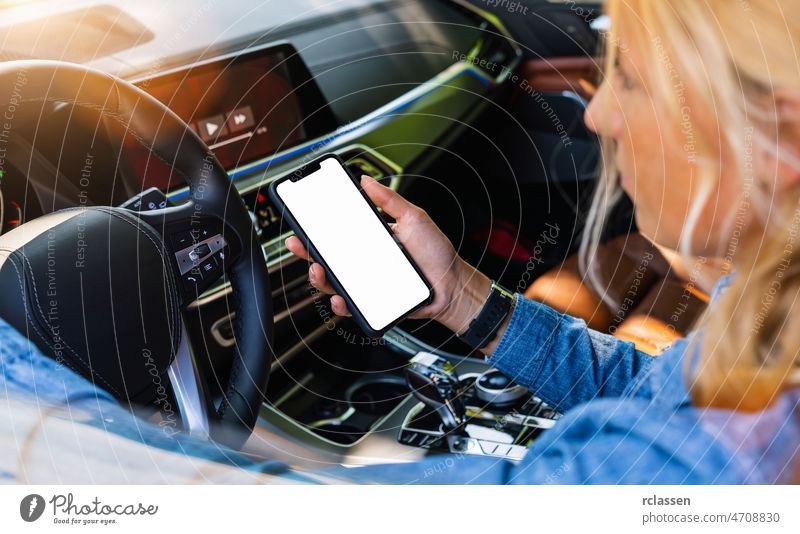 Frau hält schwarzes Handy in den Händen mit leeren Desktop-Bildschirm während der Autofahrt im Sommer in der Stadt, Mockup-Bild Telefon Laufwerk Halt