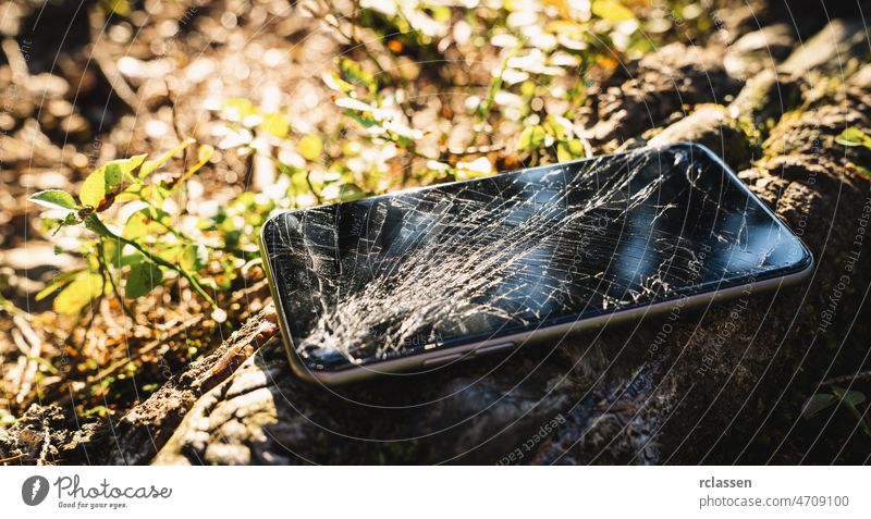 Zerbrochener Bildschirm eines Smartphones im Freien nach einer Wanderung gebrochen Telefon Wanderer Wald Mobile Anzeige Funktelefon Unfall Hintergrund schwarz