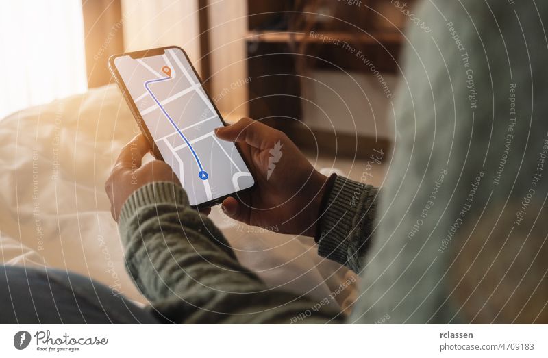 Tourist mit GPS-Karte Navigation App auf Smartphone-Bildschirm, um die Richtung zum Ziel-Adresse in der Stadt in einem Hotelzimmer, Reise-und Technologie-Konzept Bild