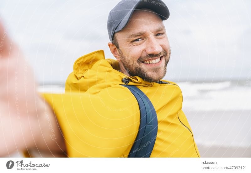 Fröhlicher bärtiger junger Mann Alleinreisender macht Selfie am Strand - Abenteuer Fernweh Konzept am Strand Glück Porträt Lächeln Person Hipster fotografierend