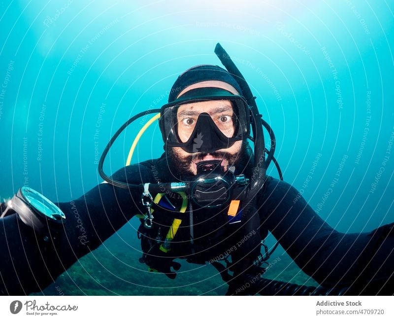 Taucher mit Schnorchelmaske macht Selfie unter Wasser Mann Selbstportrait MEER Mundschutz Hobby Sinkflug männlich Neoprenanzug schwimmen tief aqua Aktivität