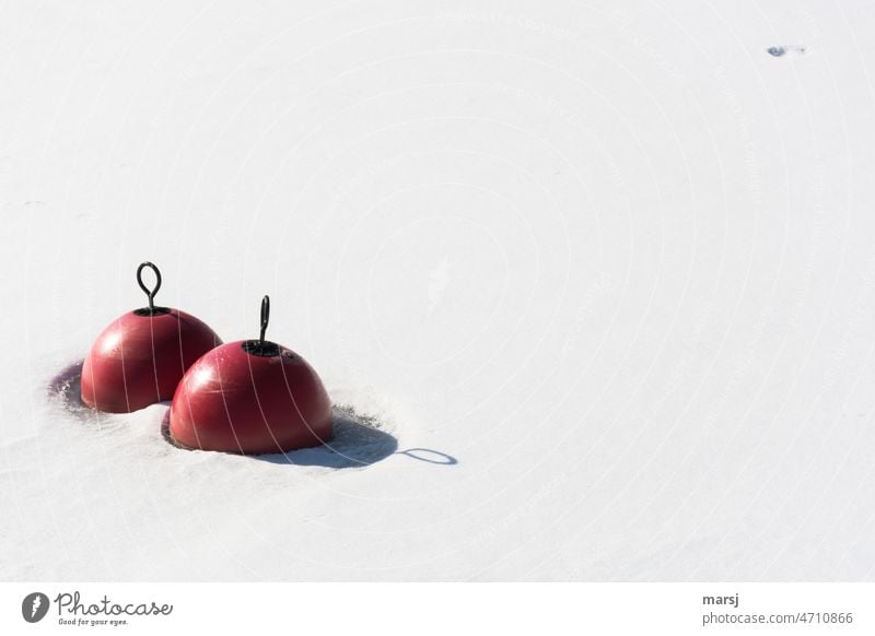 Zwei rote Bojen im Schnee. Mit Öse und deren Schatten. Ring zwei rund unberührt festgefroren Winter