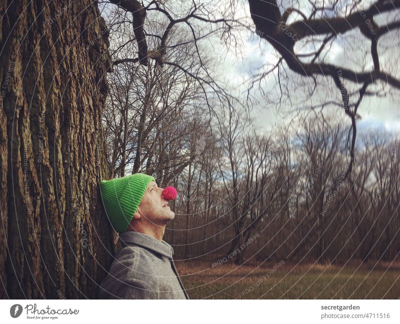 [Clown+Fun-Tour HH2022] Naturerlebnis Humor lustig Mütze Winter oben Baum anlehnen Farbfoto Mensch Mann Porträt Außenaufnahme Witz Erwachsene Blick