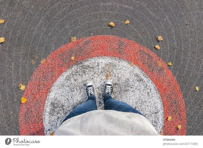 Junge Frau steht im Herbst in einem Kreis auf der Straße, persönliche Perspektive von oben. pov Menschen Lifestyle Punkt Ansicht Weg Kaukasier jung