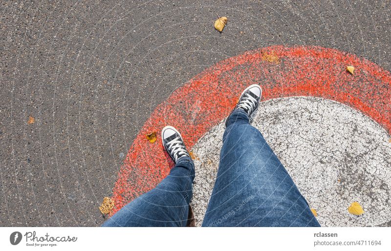 Junge Frau steht außerhalb eines Kreises auf einer roten Linie auf der Straße, persönliche Perspektive pov Menschen Lifestyle Punkt Ansicht Weg Kaukasier jung