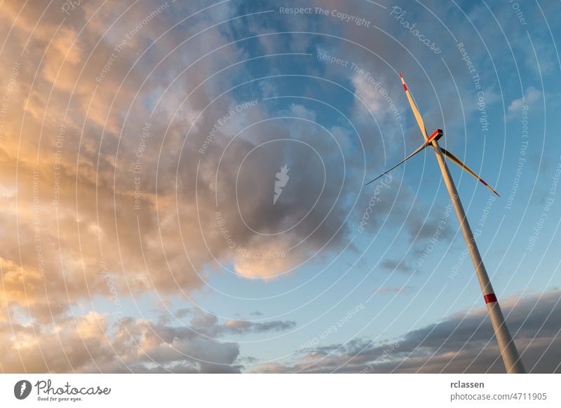 Windturbine vor bewölktem Himmel bei Sonnenuntergang Windmühle Windkraft Erneuerbare Energie Elektrizität Kraftwerk Natur Ökostrom Ökologie Windpark