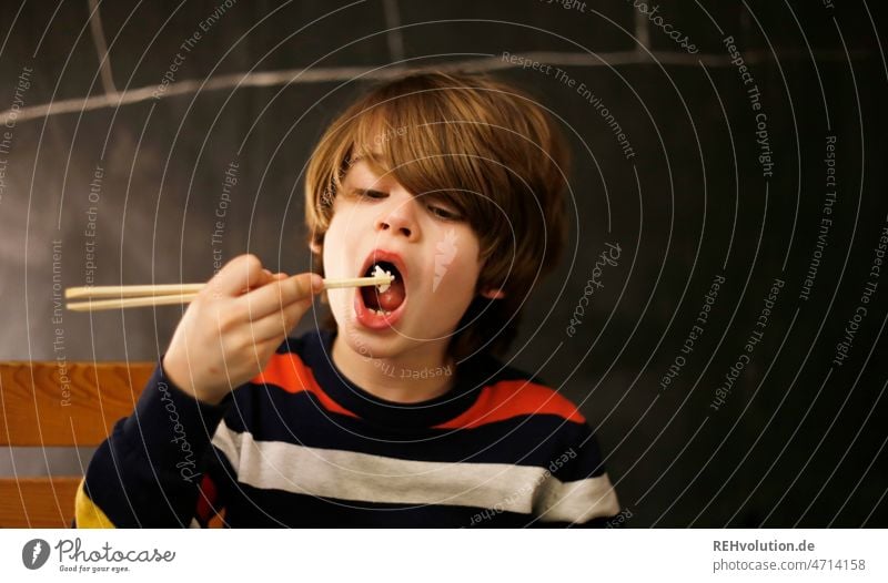 Kind isst mit Stäbchen Essen Chinesisch Reis Kindheit Junge Nahrung Lebensmittel asiatisch Abendessen Mahlzeit Hintergrund lecker Essstäbchen Speise Gesundheit
