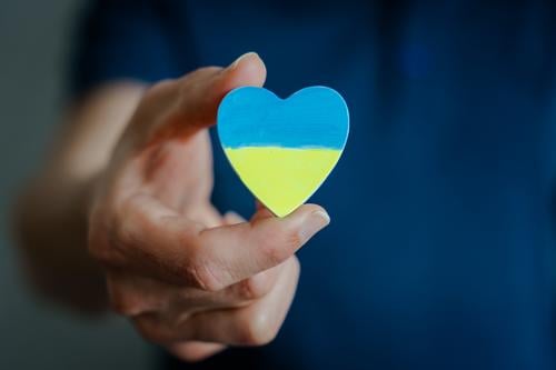 Mann hält ein Herz mit den Nationalfarben der Ukraine Nationalflagge Frieden Hoffnung Solidarität Friedenswunsch Symbole & Metaphern Politik & Staat blau gelb