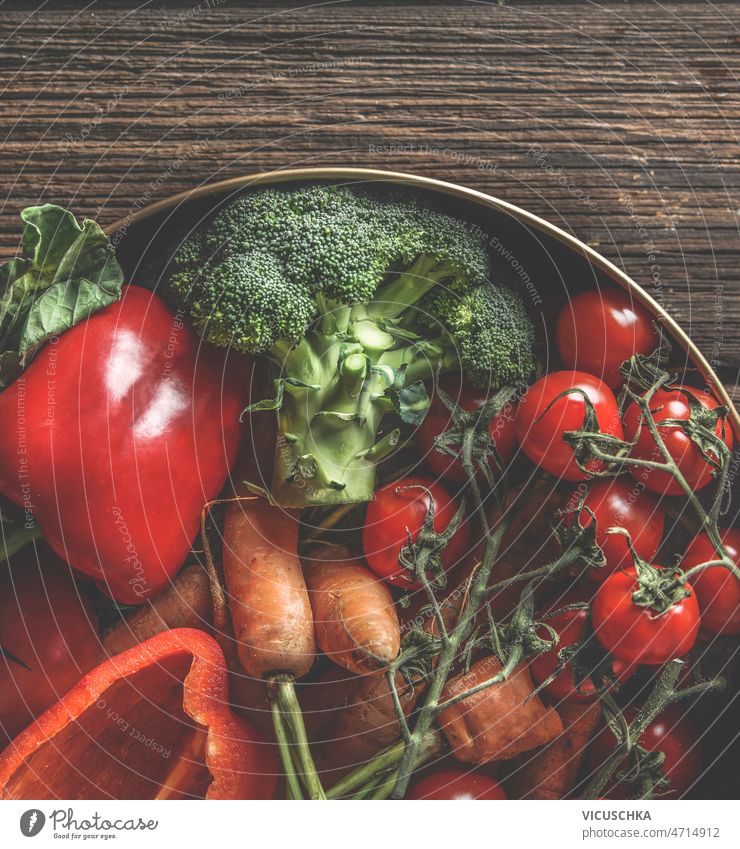 Nahaufnahme von verschiedenen bunten Gemüse in Schüssel auf rustikalen Holztisch Küche abschließen farbenfroh Schalen & Schüsseln hölzern Tisch rot Paprika