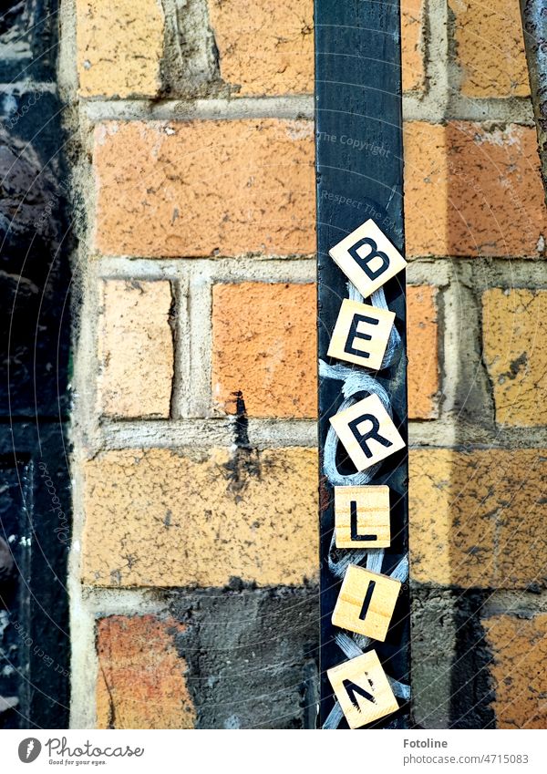 Auf kleinen hölzernen Quadraten stehen die Buchstaben BERLIN Berlin Wort Schriftzeichen Wand Mauer Fassade Zeichen Außenaufnahme Straßenkunst Mauerwerk