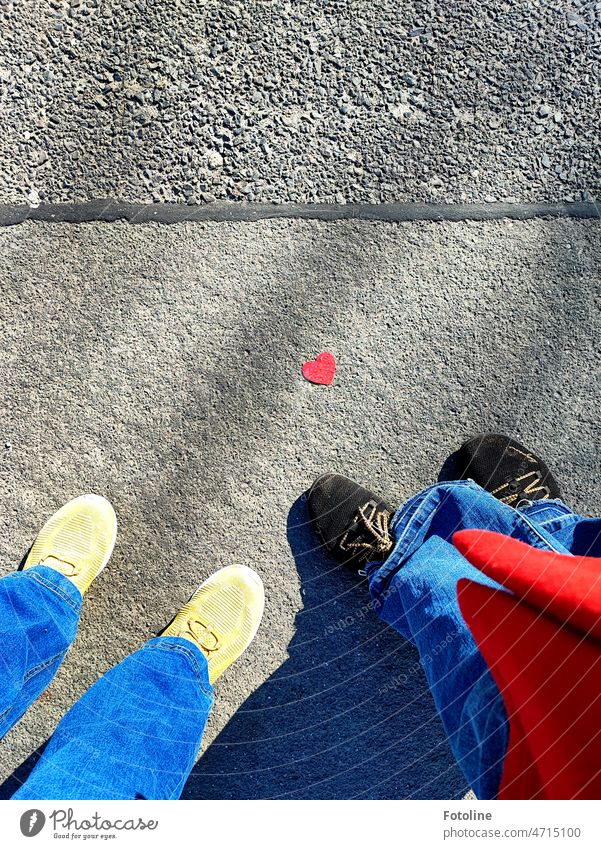 Na schau mal an, das rote Mäntelchen passt farblich perfekt zu dem kleinen roten Herz auf der Straße Liebe herzförmig Papier Zeichen Nahaufnahme Liebeserklärung