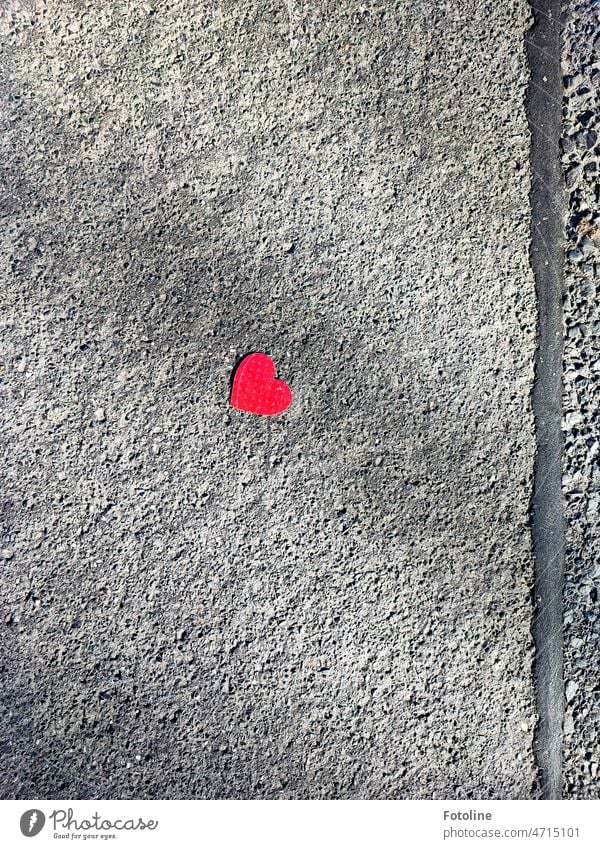 An diesem kleinen roten Herz auf dem tristen, grauen Asphalt, konnte ich einfach nicht vorbeigehen. Liebe herzförmig Papier Straße Zeichen Nahaufnahme