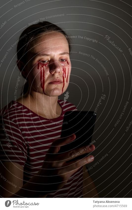 Frau liest Nachrichten und weint Blut Träne Gesicht weinen Mobbing Leiden Mobiltelefon Schmerz Missbrauch Angst grausam Kaukasier Menschliches Gesicht online