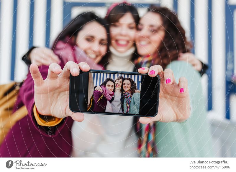 glückliche Freundinnen mit Handy vor bunten Häusern, Costa Nova, Aveiro, Portugal Frau Haus reisen Tourist genießen Tourismus Backpacker Kaukasier Glück