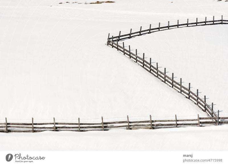 Holzzaun auf verschneiter Weidefläche, s-förmig. Ausgrenzung Grenze Zaun Sicherheit Tag Morgen Einsamkeit kalt einfach Schnee Winter Natur Barriere trennen