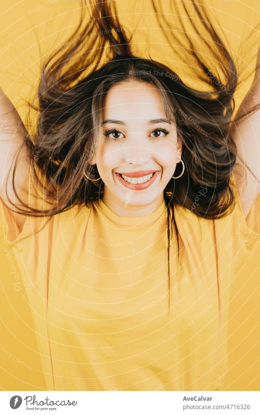 Junge afrikanische Frau winken Haare und feiern, während lächelnd in die Kamera glücklich und cool Haltung Konzept posiert isoliert über gelbe Farbe Wand Hintergrund. Tägliche Ausdrücke mit Kopie Raum im Studio.